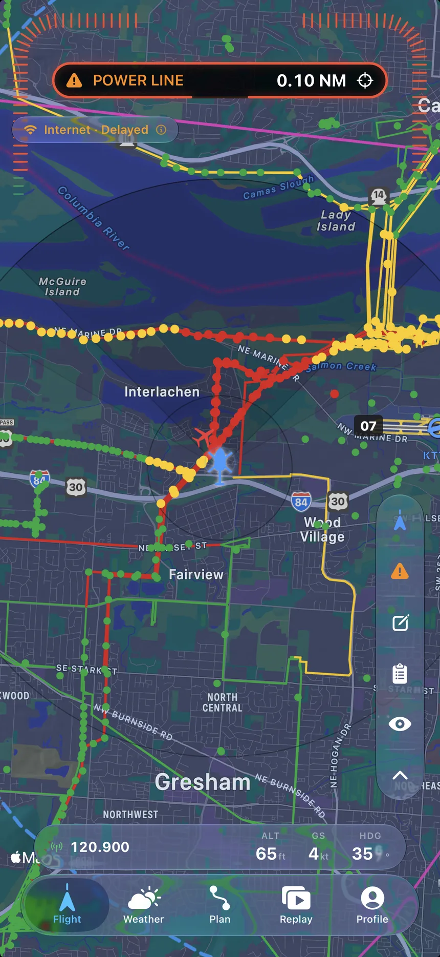 The FLYT moving map: a dark chart dense with colour-coded obstacle and power-line spans.
